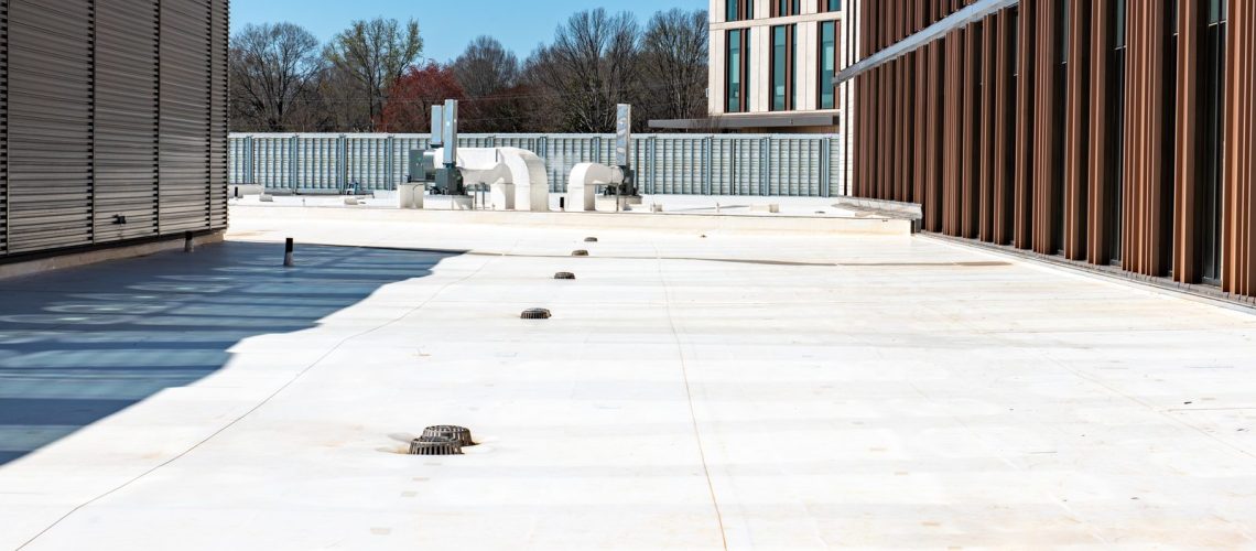 White membrane commercial roof with roof drains, walkway pads and rooftop equipment
