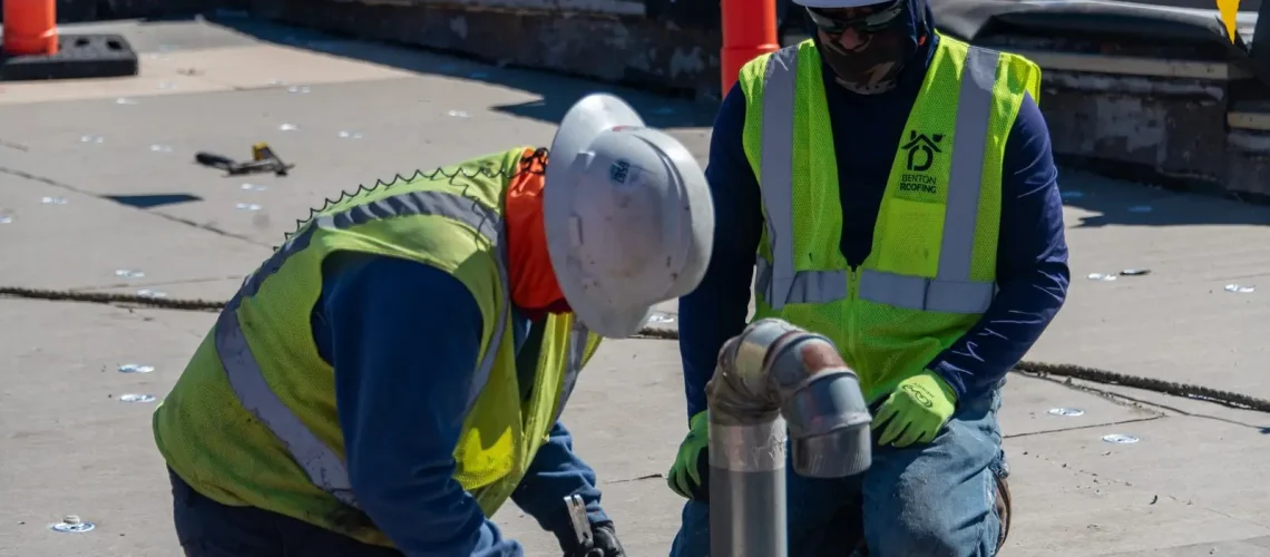 Benton Roofing crew flashing a pipe penetration on a commercial flat roof
